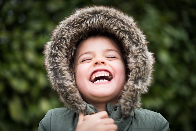 A boy laughing with all teeth showing