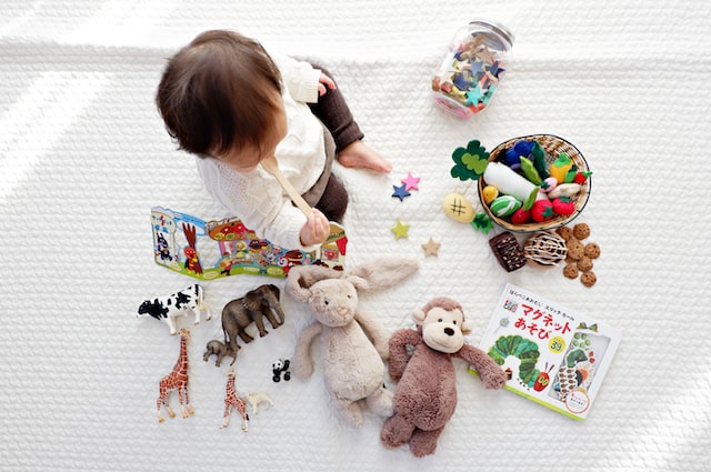 A toddler with different colored toys