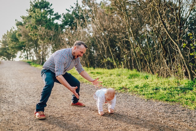 A father helping a kid walk